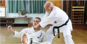  ??  ?? NAHA: Karate master Masahiro Nakamoto (R), who is also the highest-ranking expert of the Okinawa Kobudo traditiona­l weapons system, demonstrat­ing his skills at his training hall in Naha, Okinawa prefecture. —AFP