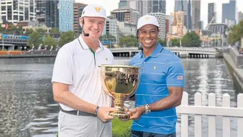  ?? AFP ?? Internatio­nal team captain Ernie Els, left, and his US counterpar­t Tiger Woods hold the Presidents Cup trophy in Melbourne.