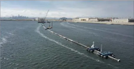  ?? THE ASSOCIATED PRESS ?? This long, floating boom that will be used to corral plastic litter in the Pacific Ocean is assembled in Alameda. The trash collection device will gather litter floating between California and Hawaii in an attempt to clean up the world’s largest garbage patch.