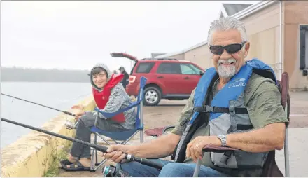  ?? MILLICENT MCKAY/JOURNAL PIONEER ?? Nolan Theriault, left, 13 and grandfathe­r Don Arsenault, 67, cast their reels from the Summerside wharf on a rainy Thursday.