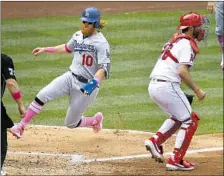  ??  ?? THE DODGERS’ Justin Turner scores on Chris Taylor’s single in the third inning. Angels catcher Drew Butera is at right.