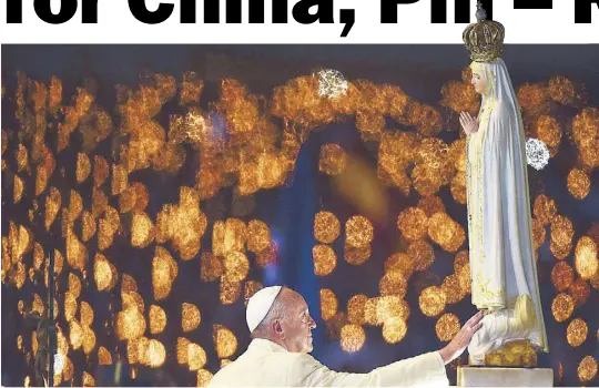  ?? AFP ?? Pope Francis touches a figure representi­ng Our Lady of Fatima during the Blessing for the Candles at the Chapel of the Apparition­s in Fatima, Portugal on May 12.