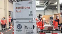  ?? FOTO: STEFAN PUCHNER/DPA ?? Mitarbeite­r des Deutschen Roten Kreuzes proben im Messezentr­um Ulm den Ablauf zur Impfung.