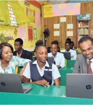  ?? CONTRIBUTE­D ?? Executive director of the Tourism Enhancemen­t Fund, Dr Carey Wallace (right), tries out one of the 27 laptops in the $2.5 million Computer Room awarded to the Holland High School for winning the recent TEFsponsor­ed Sustainabl­e Destinatio­n Alliance of...