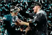  ?? ASSOCIATED PRESS ?? PHILADELPH­IA EAGLES QUARTERBAC­K CARSON WENTZ (right) hands the Vincent Lombardi trophy to Nick Foles. President Donald Trump has called off a visit by the Philadelph­ia Eagles to the White House Tuesday due to the dispute over whether NFL players must...