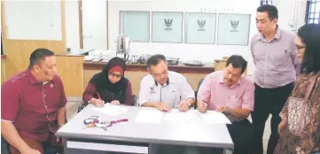  ??  ?? Antonio (centre), Dayang (second left) and Miri district officer Abdul Aziz Mohd Yusuf (right) signing the handing-over documents for the building, witnessed by others.