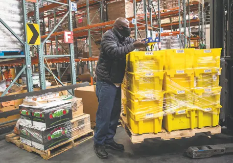  ?? Photos by Stephen Lam / The Chronicle ?? Henry Randolph, shop floor manager at the S.F.Marin Food Bank, sorts a pallet of new donations Monday.