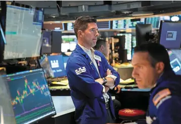  ?? ?? Cautionary stance: Traders work on the floor at the New York Stock Exchange. Money managers remains invested in highly rated short-term debt as it sees enduring price pressures. — AP