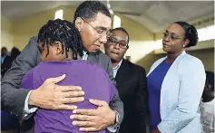  ?? GLADSTONE TAYLOR/PHOTOGRAPH­ER ?? Prime Minister Andrew Holness comforts a girl, as minister of state in the Ministry of Education, Youth and Informatio­n, Floyd Green, and the prime minister’s wife, Member of Parliament Juliet Holness, look on.