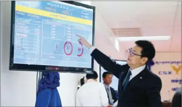  ?? HENG CHIVOAN ?? A Cambodian stock exchange official explains stock purchasing on the trading floor at the CSX office in Phnom Penh last year.