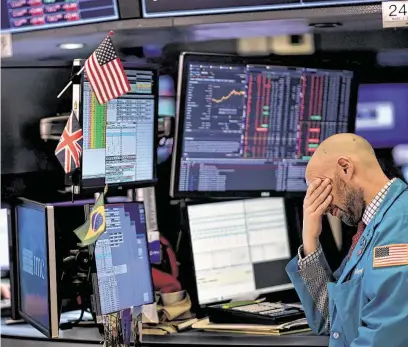  ?? Johannes Eisele / AFP via Getty Images ?? Traders work during the closing bell at the New York Stock Exchange on Monday, a day that saw the Dow Jones Industrial Average lose more than 1,000 points and the S&P 500 fall more than 3.3 percent, its biggest daily decline in two years.