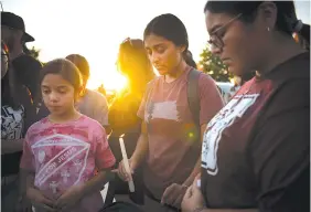  ?? MERIDITH KOHUT/THE NEW YORK TIMES ?? A prayer vigil takes place Wednesday at the county fairground­s in Uvalde, Texas, the day after a mass shooting at Robb Elementary School.
