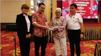  ?? ?? Lee (second left) presents a gift to one of the associatio­n’s elderly members, in the presence of Jee (left) and event’s organising chairman Yee Wing King.