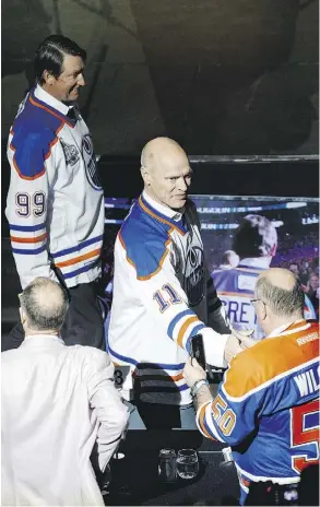  ?? CODIE MCLACHLAN ?? Mark Messier shakes hands with a fan as Wayne Gretzky walks past during the NHL’s Greatest Team celebratio­n recognizin­g the 1984-85 Edmonton Oilers at Rogers Place on Sunday.