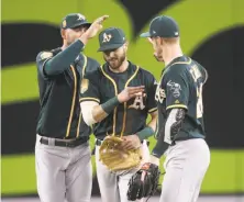  ?? Tom Szczerbows­ki / Getty Images ?? Matt Joyce ( left), Dustin Fowler and Mark Canha celebrate the A’s 3- 1 victory over the Blue Jays in Toronto.