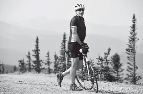  ?? Hyoung Chang, The Denver Post ?? Haze from Western wildfires obscures the mountains in the distance behind bicyclist Richard Howell of Denver, who was taking a break at Squaw Pass, near Echo Lake, on Thursday.