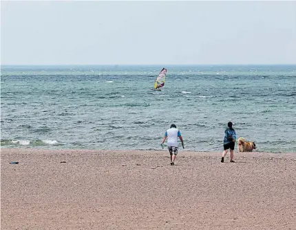  ?? JULIE JOCSAK TORSTAR ?? People enjoy a brief visit to Sunset Beach on Wednesday before being asked to leave by a St. Catharines bylaw officer.