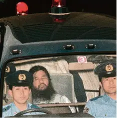  ?? Foto: afp Archiv ?? Aum Sektengrün­der Shoko Asahara im Juli 1995 auf dem Weg zu einem Gerichtste­r min: Als Langfristp­lan wollte er sogar eine Atombombe bauen.