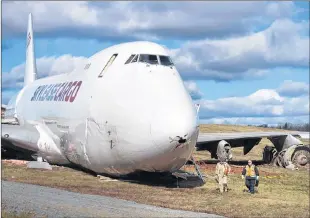  ?? ANDREW VAUGHAN /THE CANADIAN PRESS ?? Transporta­tion Safety Board investigat­ors remove flight data recording equipment Thursday from a Skylease Cargo plane that skidded off a runway, at Halifax Stanfield Internatio­nal Airport.