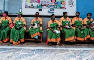  ?? AIJAZ RAHI/ASSOCIATED PRESS ?? Municipal workers wait in May at a school in Bengaluru, India, to register for coronaviru­s shots at a vaccinatio­n camp for those above age 45. As of June 21, every Indian adult can get a free COVID-19 vaccine bought by the federal government. The recent policy reversal ends a complex system of buying vaccines that worsened inequities in accessing them.