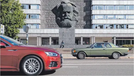  ?? FOTOS: HENDRIK SCHMIDT/DPA ?? Bis heute im Zentrum von Chemnitz: der „Nischel“, wie die Einheimisc­hen die riesige Karl-Marx-Skulptur nennen.