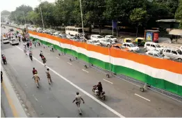  ?? — ASIAN AGE ?? A huge tricolour is seen during the 3-day Meerut to Delhi march by members of Jansankhya Samadhan Foundation to demand ‘two-child policy for all’ in New Delhi on Sunday.