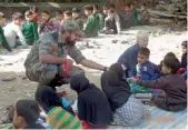  ?? — PTI ?? A jawan provides free coaching to students during Operation School Chalo by the Army at Awantipora in South Kashmir on Sunday.