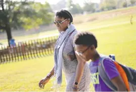  ?? THE ASSOCIATED PRESS ?? Corrie Davis, left, picks up her son Turner from Big Shanty Elementary School in Kennesaw, Ga., on Wednesday.