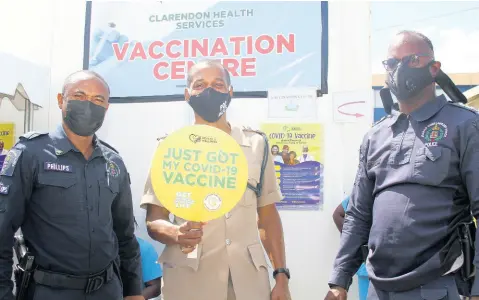  ?? NATHANIEL STEWART/PHOTOGRAPH­ER ?? Senior Superinten­dent of Police Glenford Miller (centre) is flanked by Superinten­dent Christophe­r Phillips (left) and Deputy Superinten­dent Anton-Gur Cardoza after getting the COVID jab yesterday at the May Pen Hospital in Clarendon.