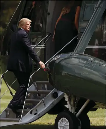  ??  ?? President Donald Trump follows first lady Melania Trump as they board Marine One on the South Lawn of the White House in Washington, Friday, en route to Camp David, Md. AP PHOTO/CAROLYN KASTER