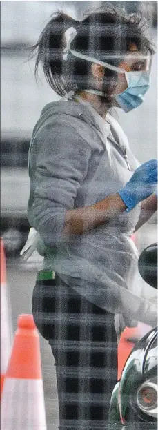  ??  ?? A member of the medical team takes a swab at a drive-thru coronaviru­s testing centre for essential workers at Glasgow Airport’s long-stay car park yesterday