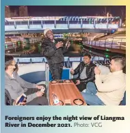  ?? Photo: VCG ?? Foreigners enjoy the night view of Liangma River in December 2021.