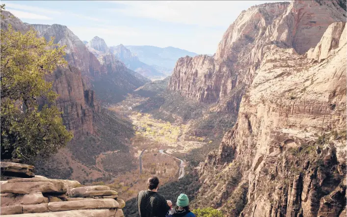  ?? NIKKI BOLIAUX/THE NEWYORKTIM­ES PHOTOS ?? Hikers take in the view Nov. 23 from the summit of the Angels Landing trail in Zion National Park in Utah, where the number of visitors has surged.