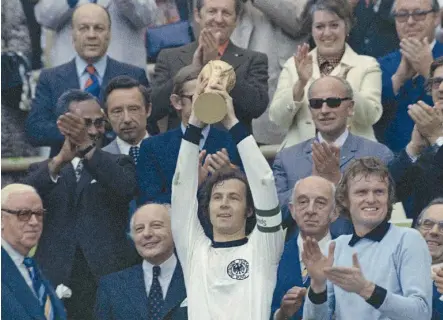  ?? / AP ?? Inolvidabl­e. Franz Beckenbaue­r en la postal de Alemania 1974, con el “Káiser” levantando la Copa del Mundo.