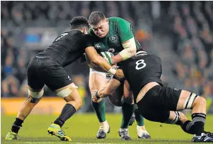  ?? Picture: GETTY IMAGES/BRENDAN MORAN ?? BUMPY RIDE: Ireland’s Tadhg Furlong is tackled by Ardie Savea and Kieran Read of New Zealand during the Guinness Series Internatio­nal match. The All Blacks seem to lose spark in 2018 despite their dominance.