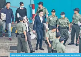  ?? — AFP ?? HONG KONG: Pro-independen­ce protestor Edward Leung (center) leaves the Lai Chi Kok Reception Centre for the High Court yesterday.