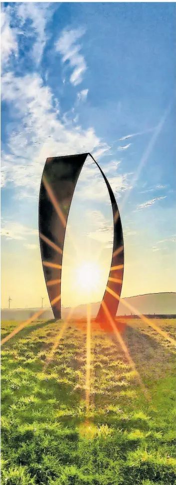  ?? FOTO: GÜNTER ENDRES ?? Die Sonne erstrahlt inmitten der beiden segelförmi­gen Dreiecke der Stahlplast­ik „Wortsegel“bei Sotzweiler. Das „Denkmal für Poesie“wurde von Professor Heinrich Popp geschaffen.