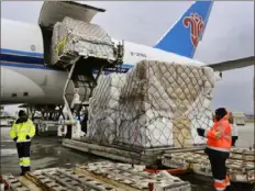  ?? Richard Vogel/Associated Press ?? Ground crew members at Los Angeles Internatio­nal Airport unload pallets of medical personal protective equipment from a China Southern Cargo flight in April 2020.