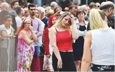  ?? AP ?? People attend a ceremony to honour the shooting victims near the City Hall in Liege, Belgium, yesterday.