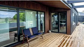  ?? ?? The home has large glass windows and sliding doors. Heat gain is minimised in summer through the overhang and internal blinds.