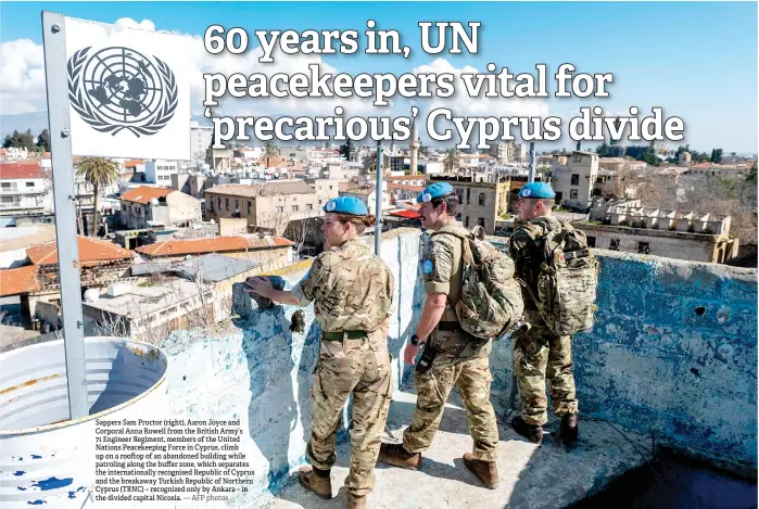  ?? — AFP photos ?? Sappers Sam Proctor (right), Aaron Joyce and Corporal Anna Rowell from the British Army’s 71 Engineer Regiment, members of the United Nations Peacekeepi­ng Force in Cyprus, climb up on a roo op of an abandoned building while patroling along the buffer zone, which separates the internatio­nally recognised Republic of Cyprus and the breakaway Turkish Republic of Northern Cyprus (TRNC) – recognized only by Ankara – in the divided capital Nicosia.