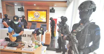  ??  ?? Indonesian Policemen arrange chemical substances for making explosives seized from suspected terrorist Rio Priatna Wibawa during a press conference of the seized suspected terrorist Rio Priatna Wibawa at Indonesian National Police headquarte­rs in...