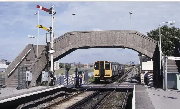  ??  ?? (BELOW) With the iron ore unloading cranes at Bidston Dock in Birkenhead visible in the distance, No. 508136 leaves Leasowe with a West Kirby to Liverpool train on the 6th August 1990. The signal box, level crossing gates and semaphore signals were still in use at this date.