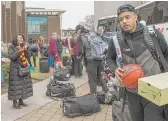  ?? TYLER LARIVIERE/ SUN- TIMES PHOTOS ?? Loyola players gather luggage after arriving on campus Sunday.