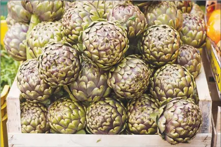  ?? PHOTOS BY SUSAN WRIGHT / THE NEW YORK TIMES ?? Artichokes are displayed at a produce market in Rome. The chief rabbinate of Israel recently declared that the dish carciofo alla Giudia, or Jewishstyl­e artichoke, was not kosher. Many Jews in and around Rome, where the specialty dish and cash crop...