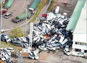  ?? JIJI PRESS/AFP ?? Vehicles lie piled in a heap due to strong winds in Kobe in Hyogo prefecture on Wednesday after typhoon Jebi hit the west coast of Japan.