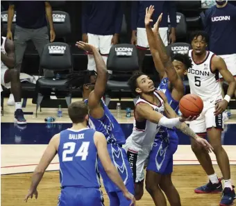  ?? AP ?? IN THE LANE: Connecticu­t guard James Bouknight hits a scoop shot against Creighton guard Denzel Mahoney (34) in the second half on Sunday in Storrs, Conn.