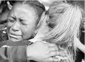  ?? GERALD HERBERT/ASSOCIATED PRESS ?? Marla Eveillard cries as she hugs friends before a vigil at Parkland Baptist Church for the school shooting victims.