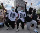  ?? Photograph: Seth Herald/AFP/ Getty Images ?? Protesters raise their fists as they kneel in front of a police station in Detroit, Michigan, on Saturday.