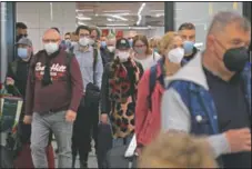  ??  ?? Passengers wearing face masks arrive at the airport in Mallorca. (AP/Francisco Ubilla)